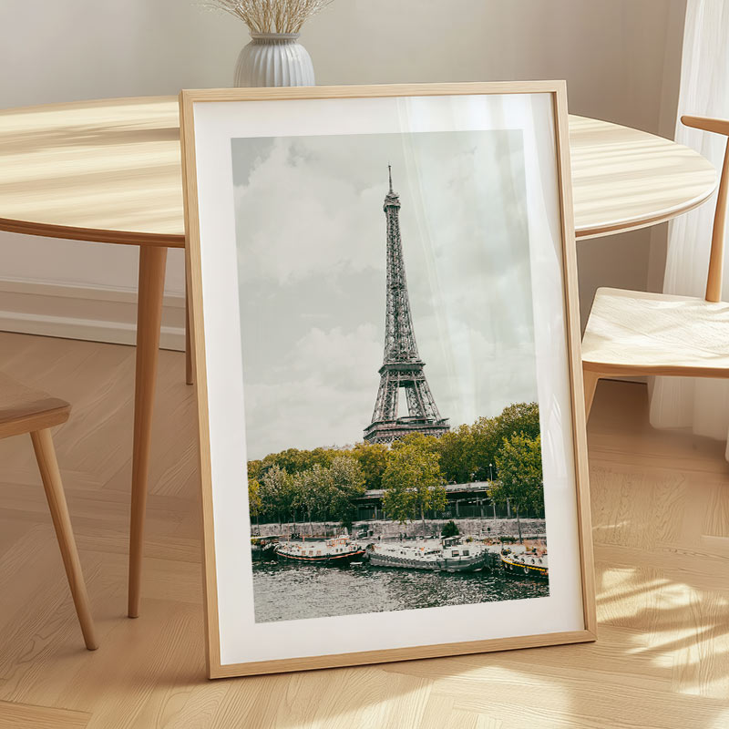 Framed picture of the Eiffel Tower on a wooden table with a neutral background