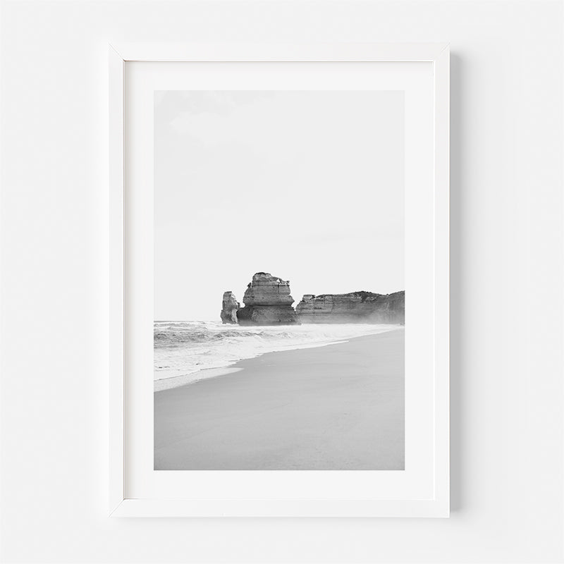 Framed black and white photograph of a beach with rock formations.