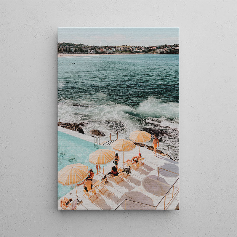 People lounging by a pool with ocean view on a sunny day
