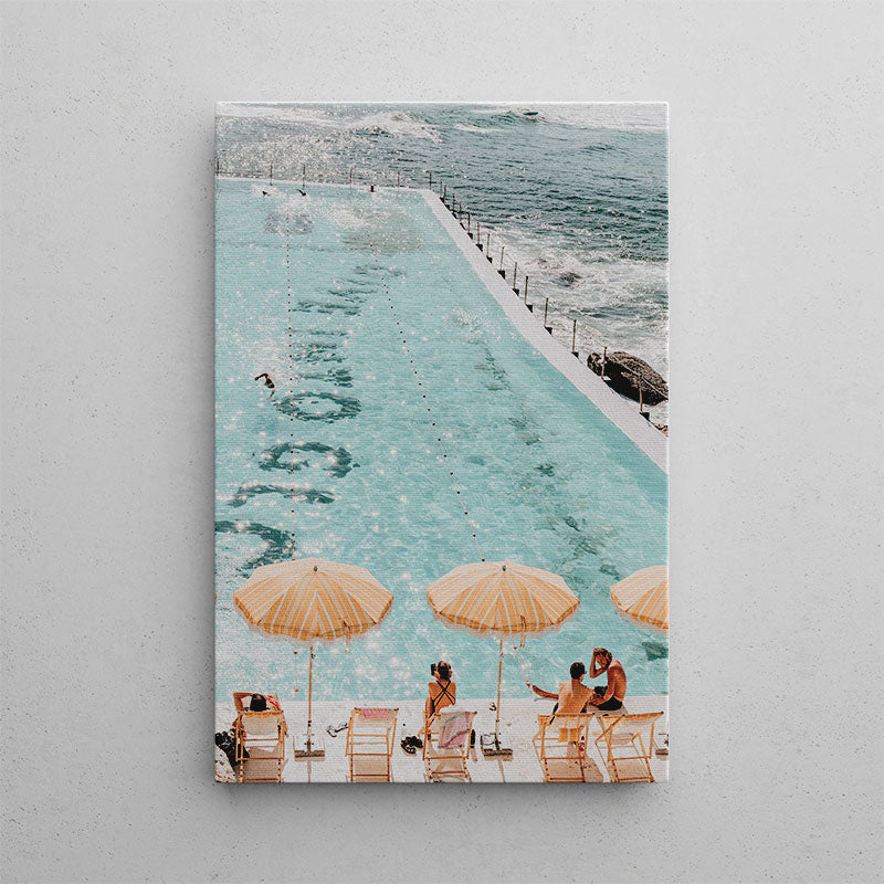 People sitting under umbrellas by a pool with ocean view
