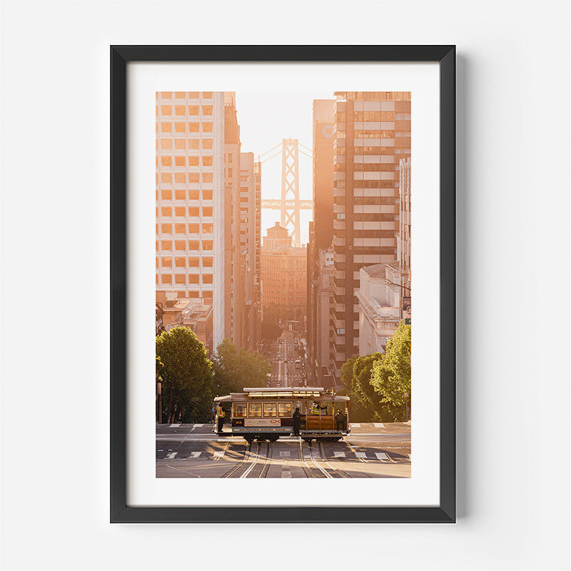 Framed photograph of a cityscape with a trolley and tall buildings.