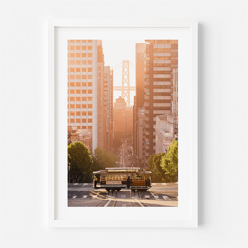 Framed cityscape print with a cable car and skyline at sunset.