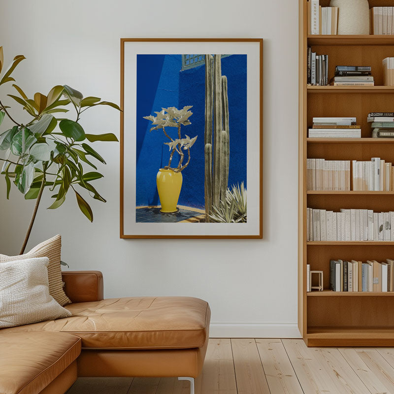 Living room with brown leather sofa, bookshelf, and framed artwork on the wall.