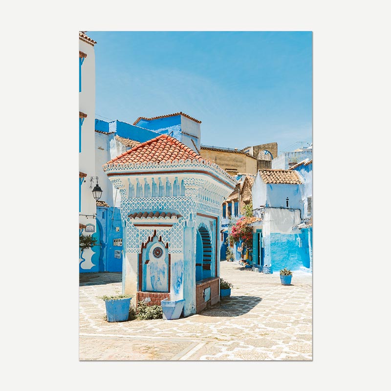 Colorful street scene with blue and white buildings in a Mediterranean town.