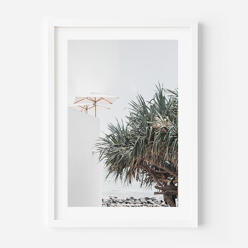 Framed photograph of a palm tree and umbrella on a beach