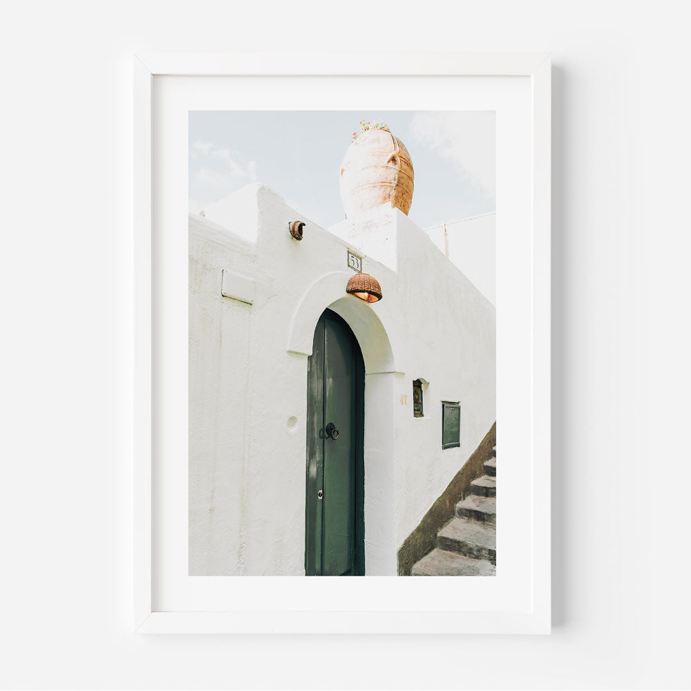 Serene Italian village facade with green door and rugged textures presented as framed coastal wall art.