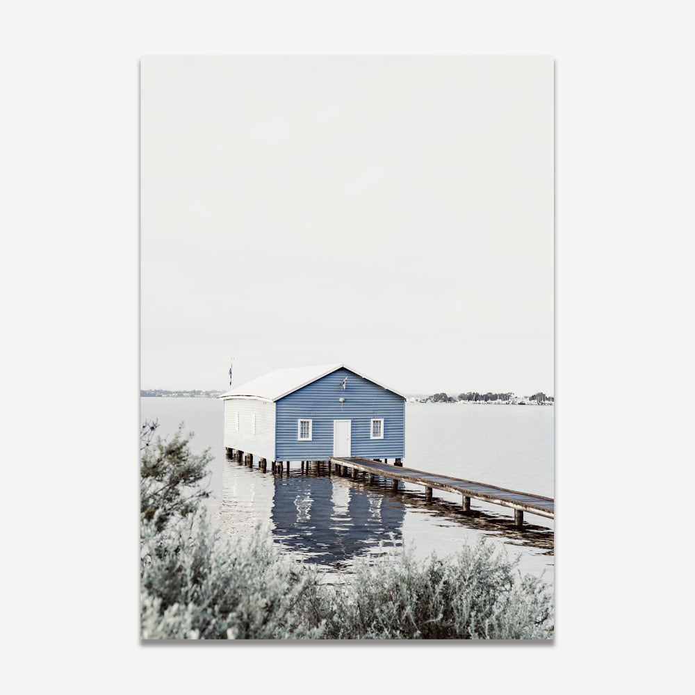 A fine art print featuring a blue boat house on a calm waterway with a clear reflection, titled 'Crawley Edge Boatshed, Perth Western Australia'.