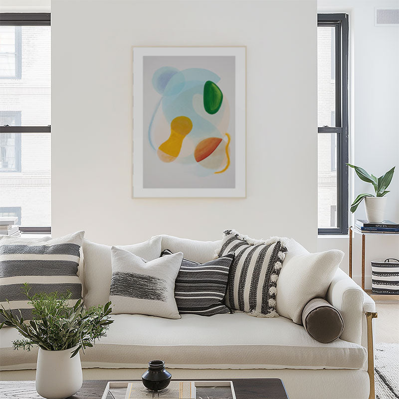 Living room with a white sofa, decorative pillows, and abstract art on the wall.
