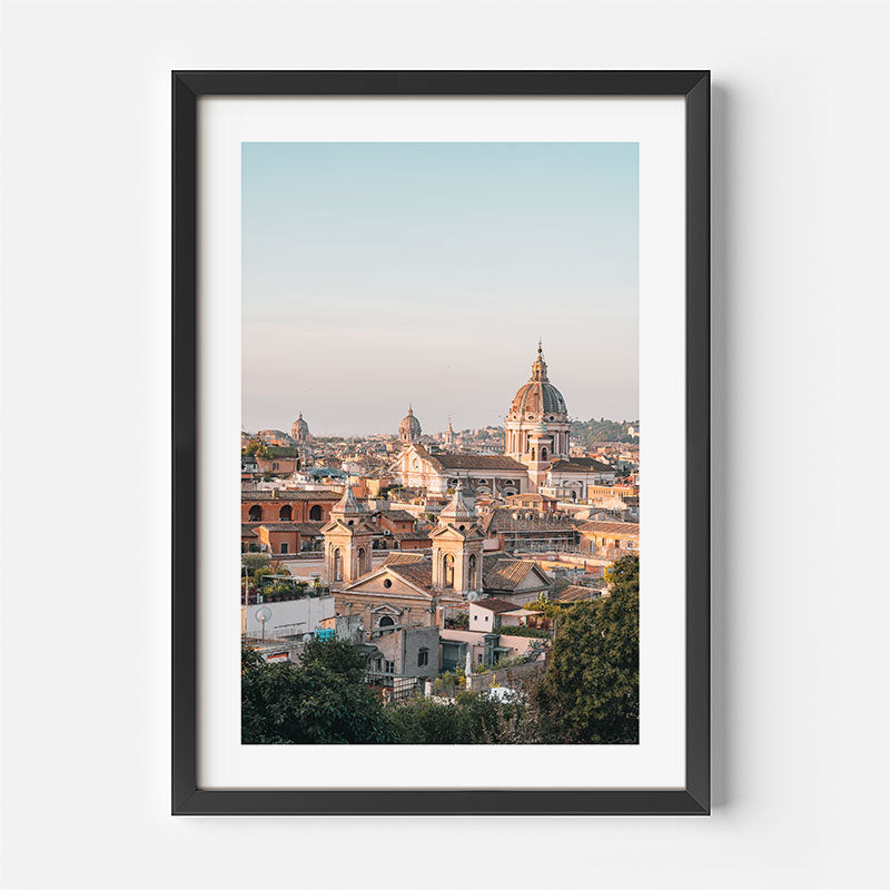 A framed art print featuring a scenic photograph of a historic city skyline with prominent domes and rooftops, displayed on a clean white wall.