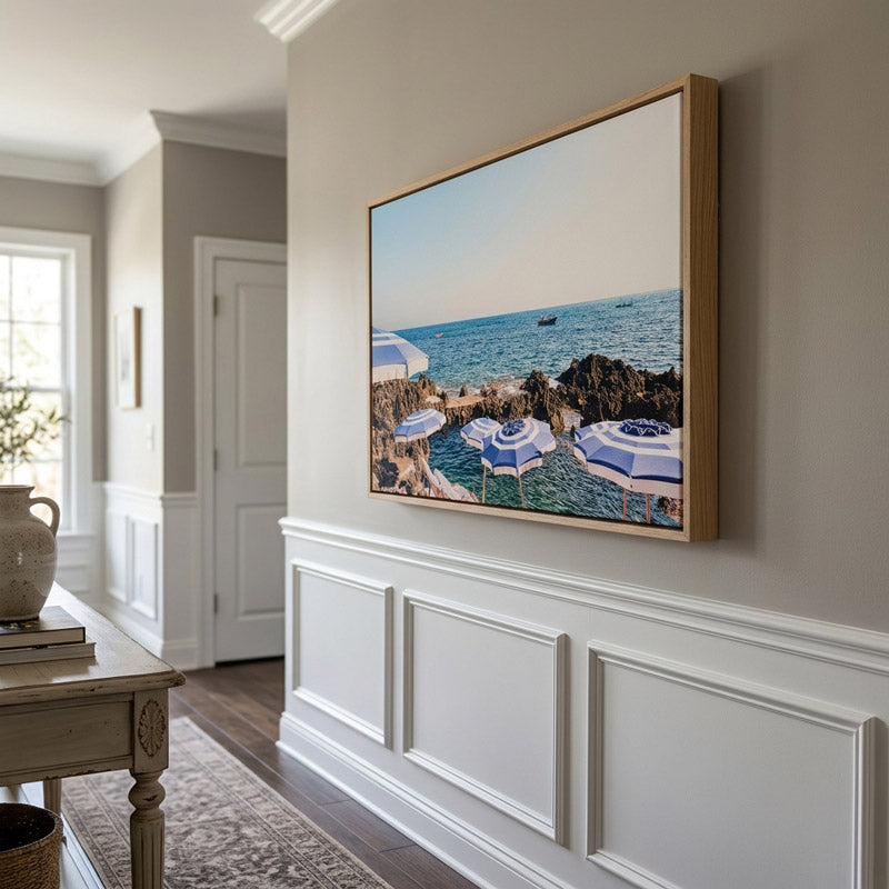 Framed artwork of a beach scene on a wall in a home interior.