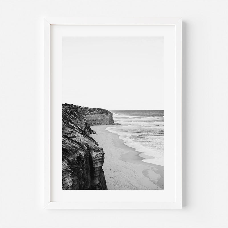 Framed black and white beachscape with cliffs on a white background