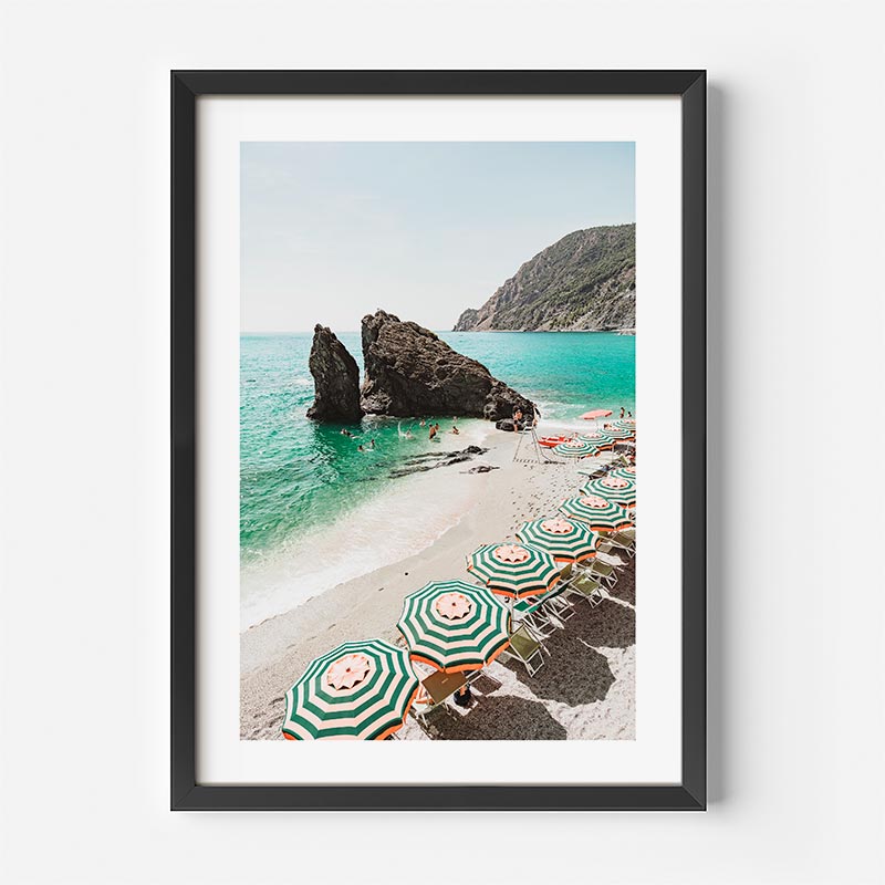 Framed photograph of a beach scene with umbrellas and chairs.