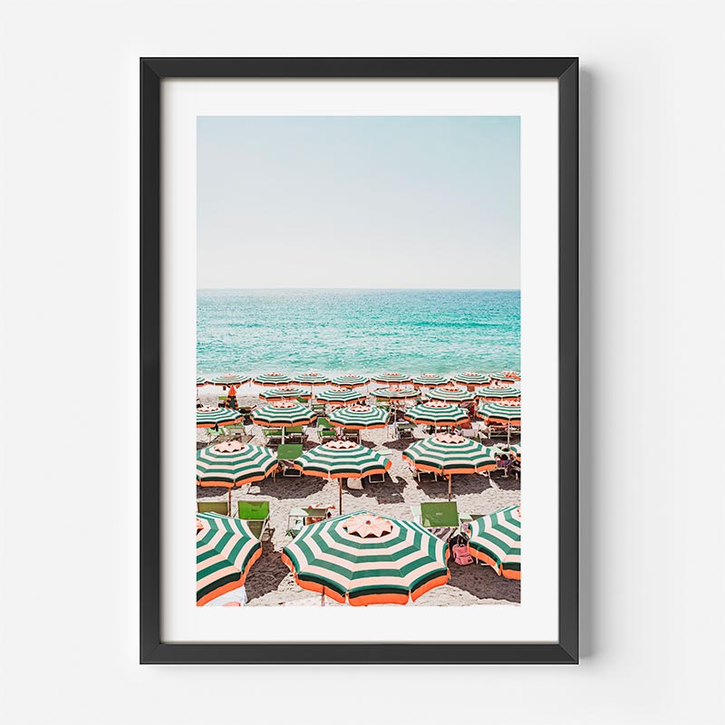 Framed artwork of a beach scene with colorful umbrellas and turquoise water.