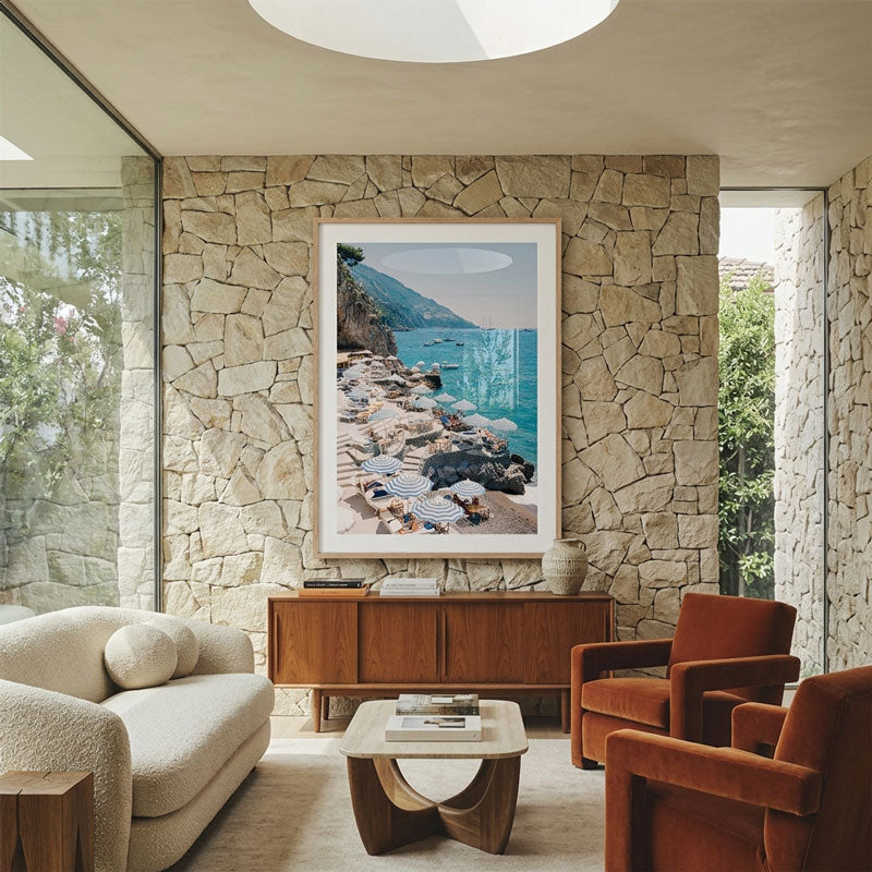 Modern living room with stone wall, artwork, and furniture.