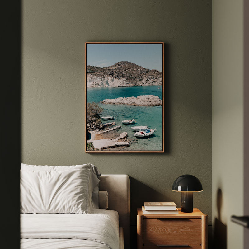 Framed artwork of a coastal scene above a sofa in a living room.