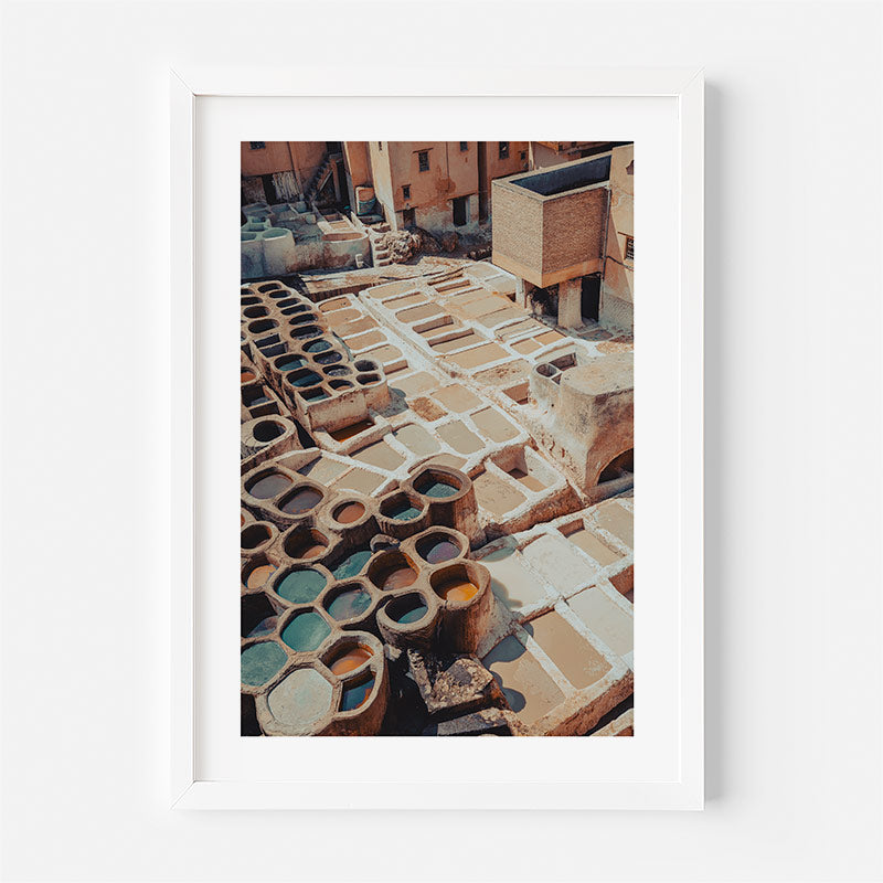 Framed photograph of a tannery with vats and leather pieces.