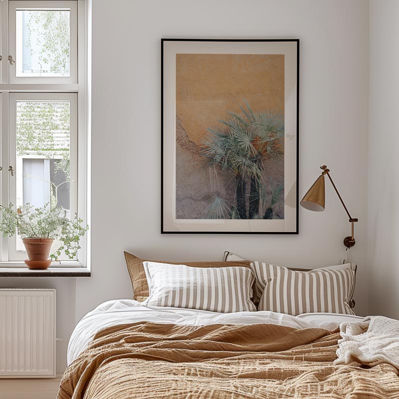 Cozy bedroom with a bed, framed artwork, and lamp.