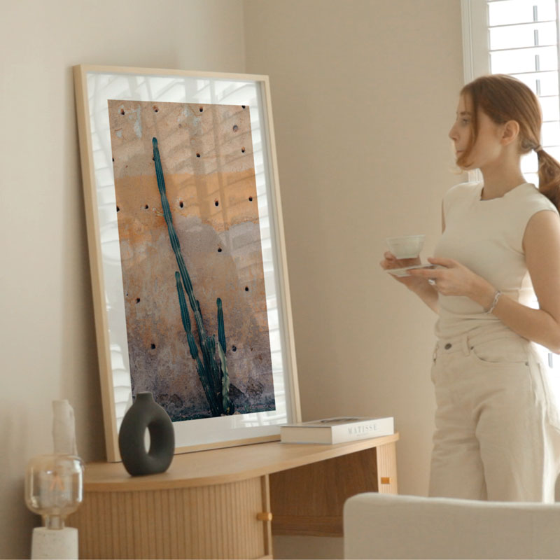 Woman standing in a living room with a large abstract painting on the wall.