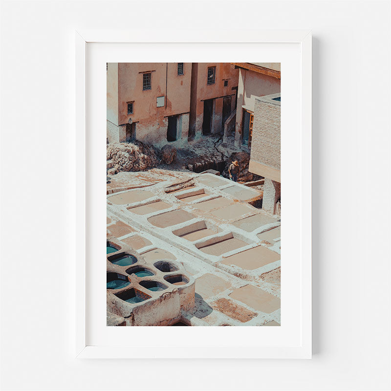 Framed photograph of a traditional ceramic potter’s wheel in an outdoor setting.