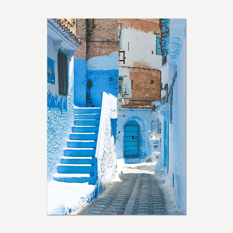 Tiled image of a narrow street with blue walls and a blue door in Chefchaouen, Morocco.