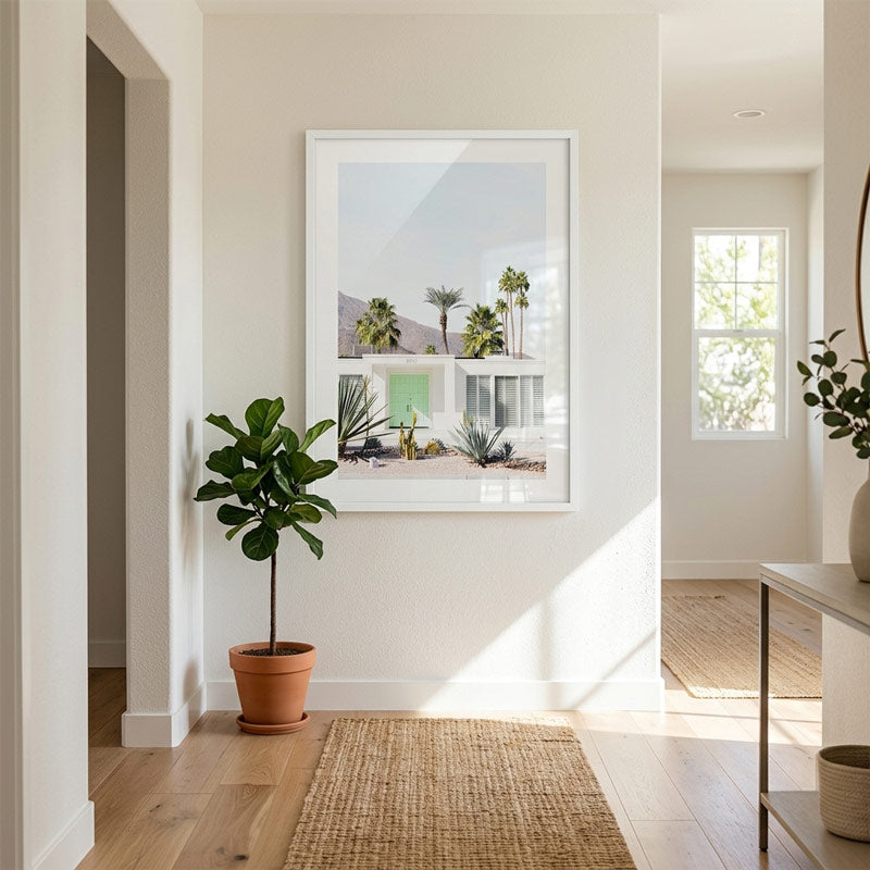 Framed artwork of a desert scene with palm trees in a modern interior setting.