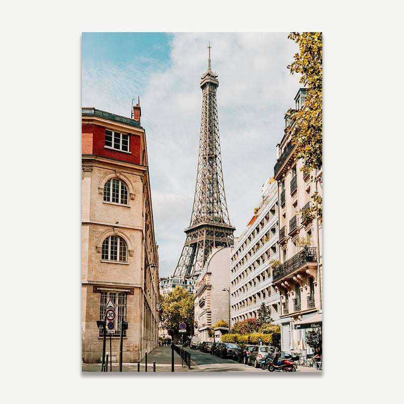 Eiffel Tower framed by buildings on a city street