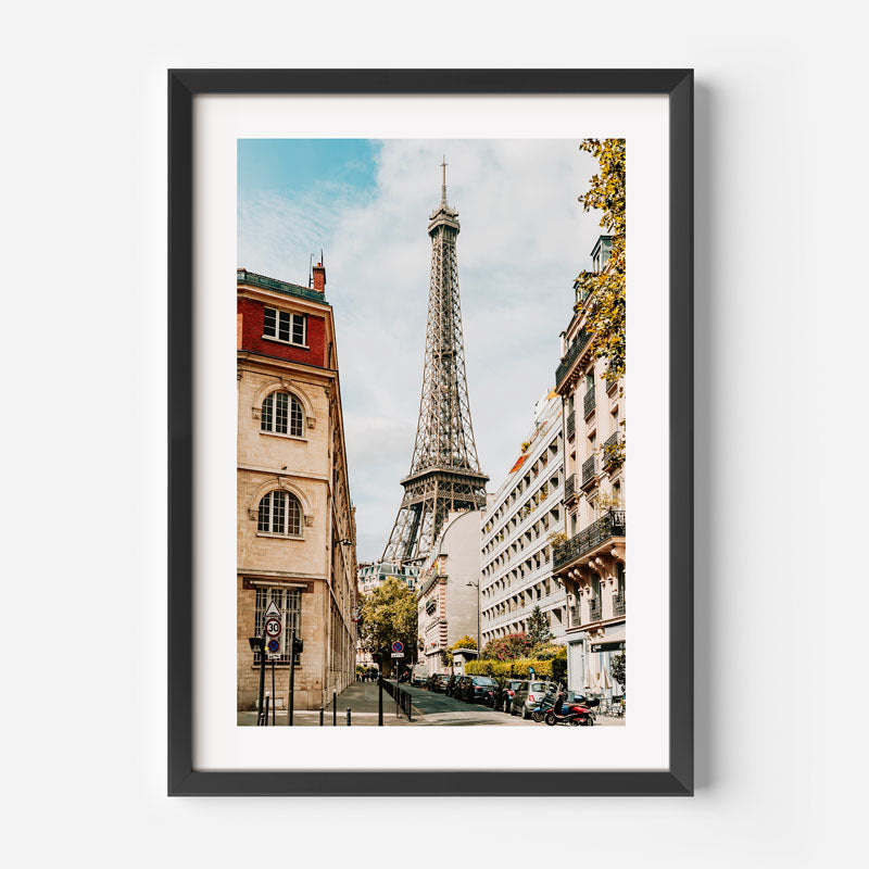 Framed photograph of the Eiffel Tower in Paris with a city street in the foreground.