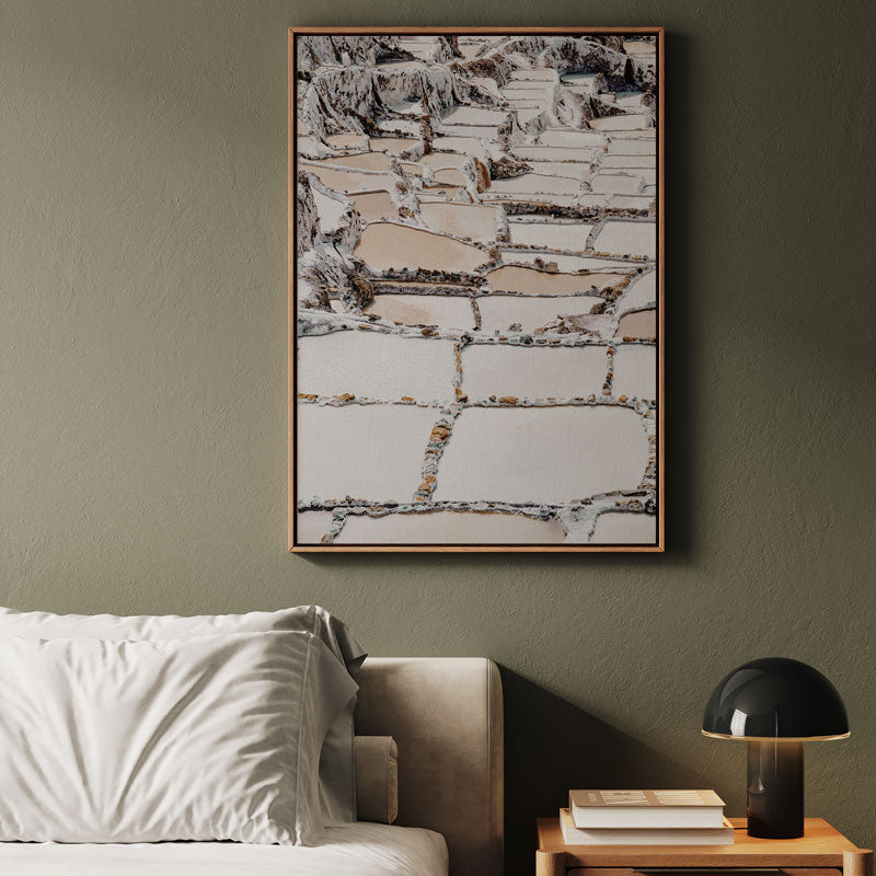 Framed abstract art piece on a wall above a sofa with a side table and lamp.