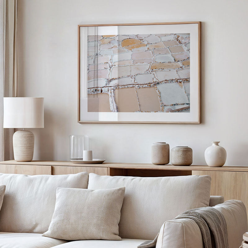 Modern living room with a neutral color palette, featuring a sofa, lamp, and abstract art on the wall.