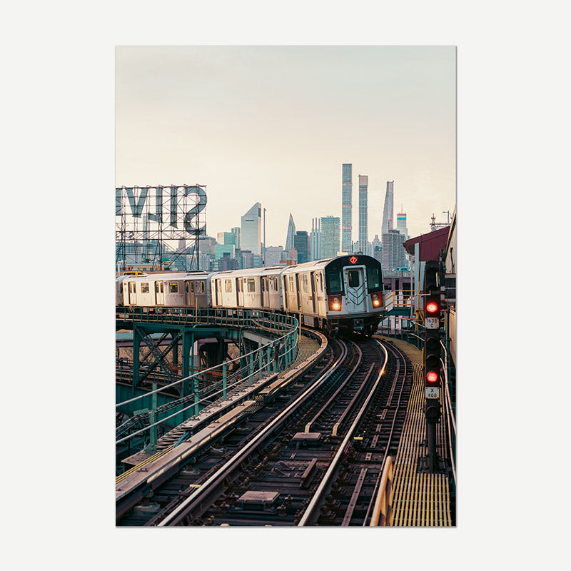 Train on elevated tracks with a city skyline in the background
