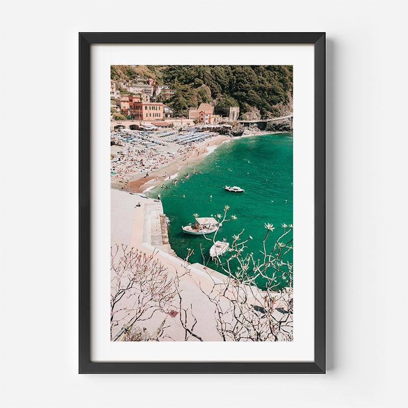 Framed photograph of a coastal scene with boats and a village.