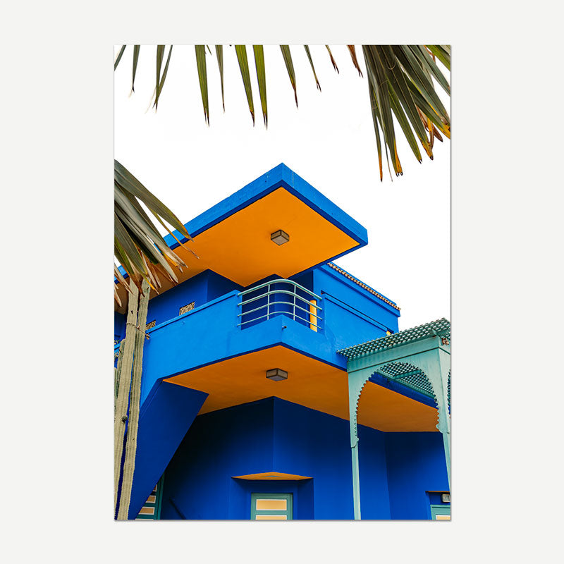 Colorful building with blue and orange facade, palm tree in the foreground