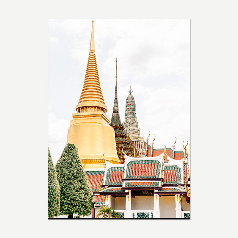A vertical photographic print of the Grand Palace and Big Buddha in Bangkok, featuring a large golden chedi, smaller spires, and traditional tiled roofs against a pale sky, shown with a light gray border.