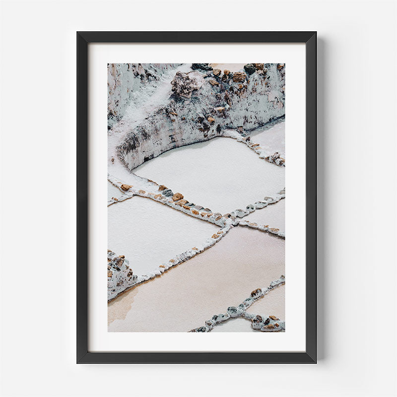 Framed photograph of a salt mine landscape with geometric patterns on a white wall.