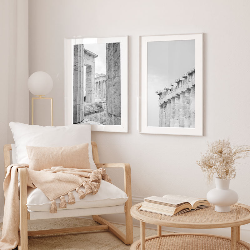 Cozy living room with a wooden armchair, wicker table, and framed black and white artworks on the wall.