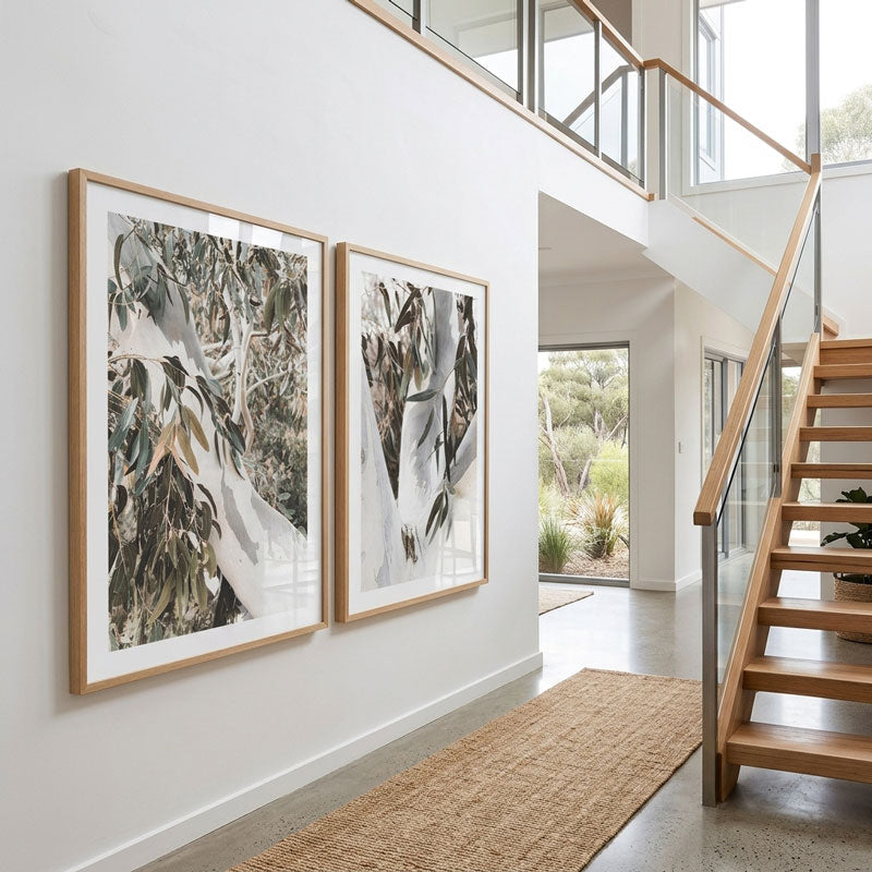 Modern interior with two framed artworks on a wall and a staircase.