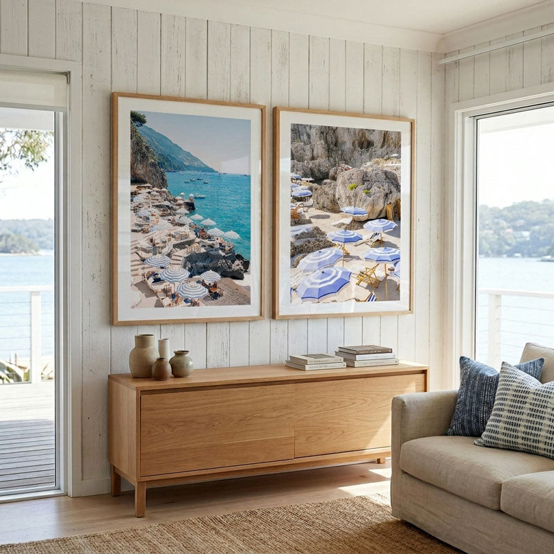 Living room with framed beach scenes on the wall, wooden sideboard, and beige sofa.
