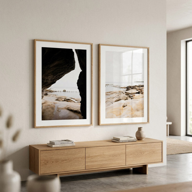 Two framed artworks on a wall above a wooden console table in a modern living room.