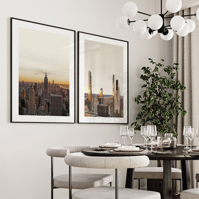 Dining room with framed cityscape art, modern chandelier, and table setting.
