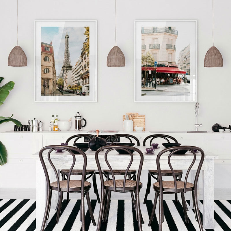 Dining area with a table and chairs, framed pictures on the wall, and a striped rug.