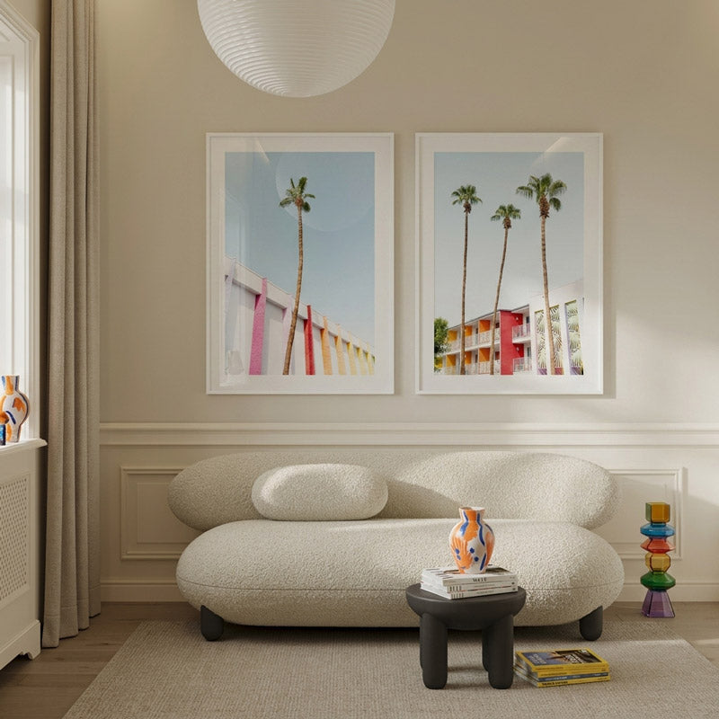 Modern living room with a textured sofa, small table, and wall art of palm trees.