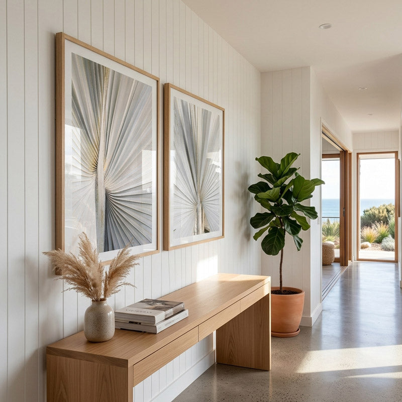 Modern interior with framed artwork, a wooden bench, and a plant.