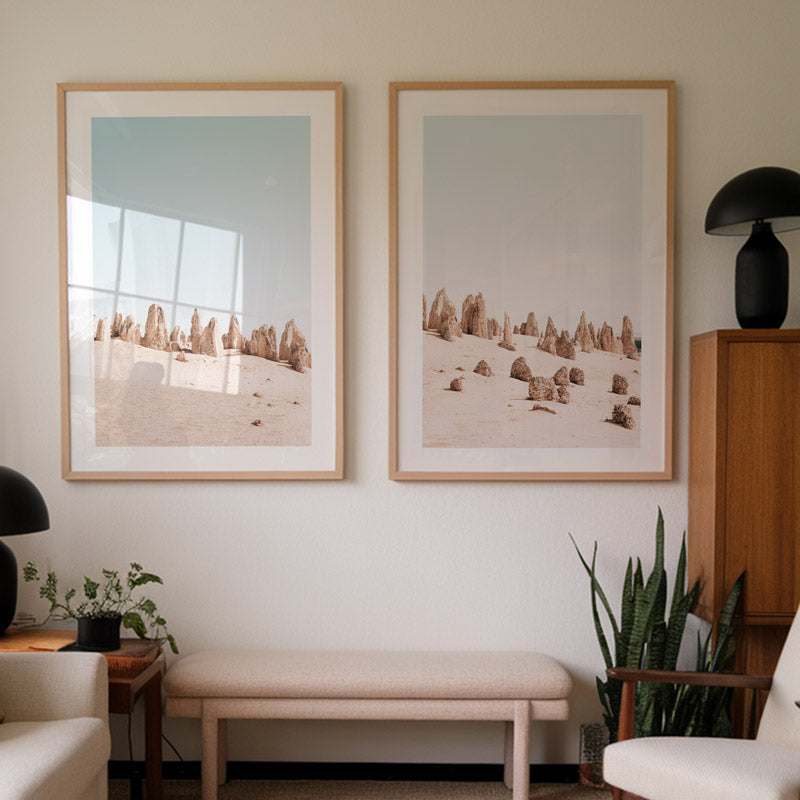 Living room with two framed landscape pictures on the wall, a bench, and plants.