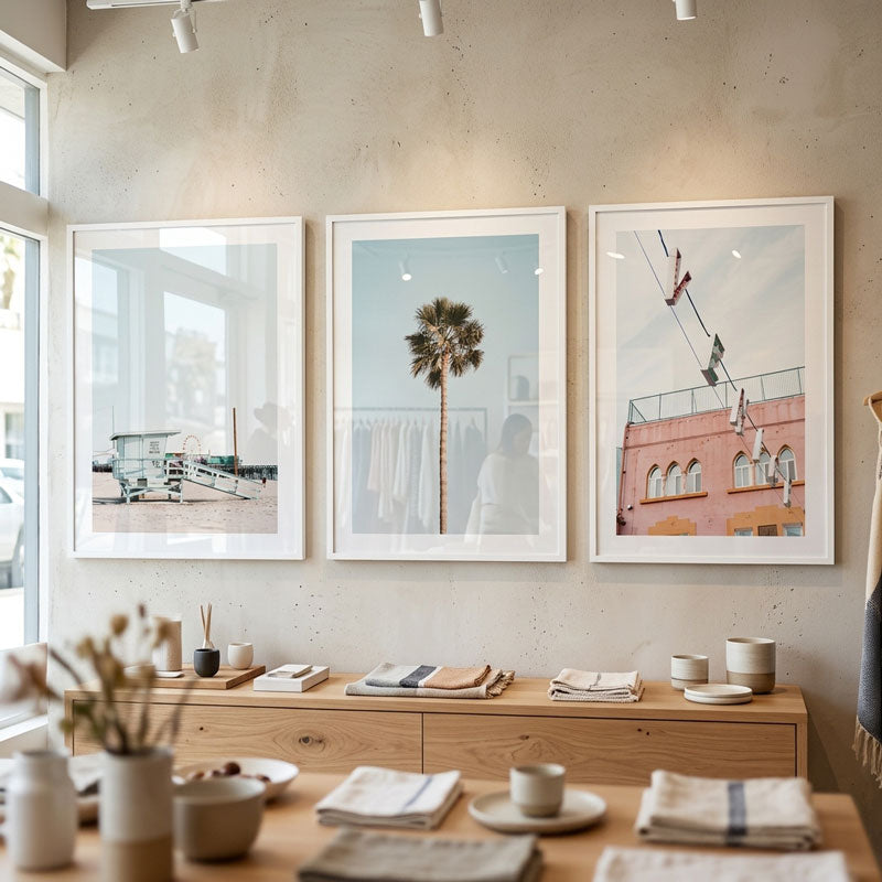 Three framed artworks on a wall above a wooden console table with decorative items.