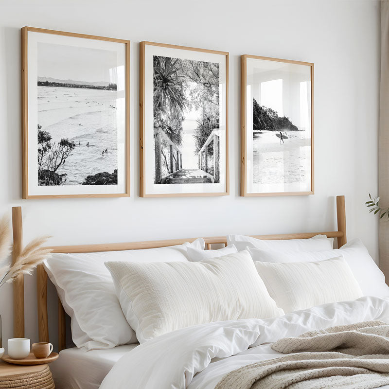 Bedroom with framed black and white landscape prints on the wall above a bed.