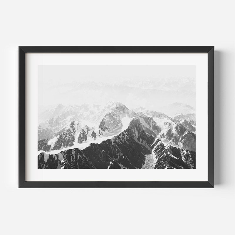 Framed black and white mountain landscape print on a white wall