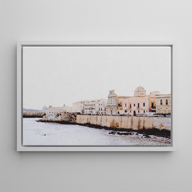 Framed photograph of a coastal cityscape with buildings and water.