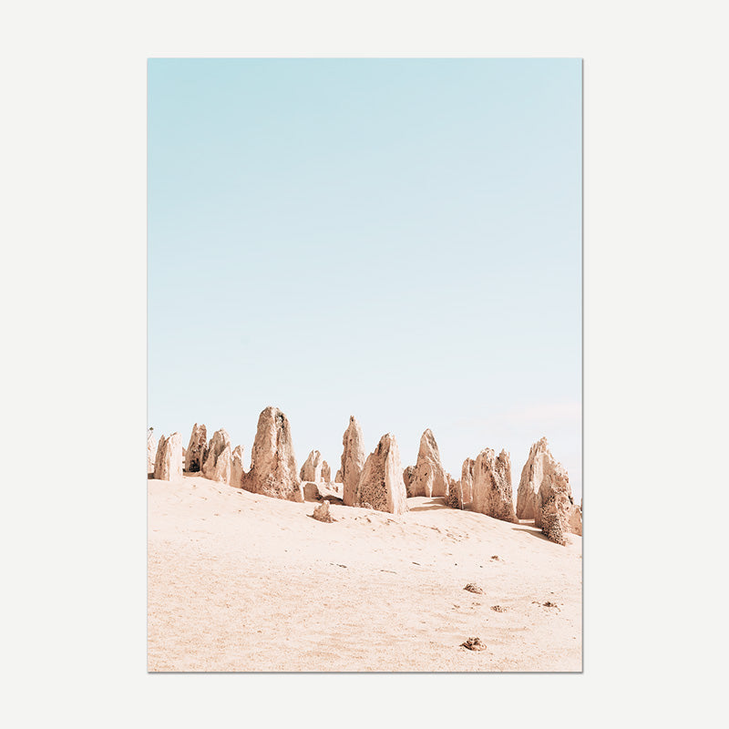 Desert landscape with rock formations against a light blue sky