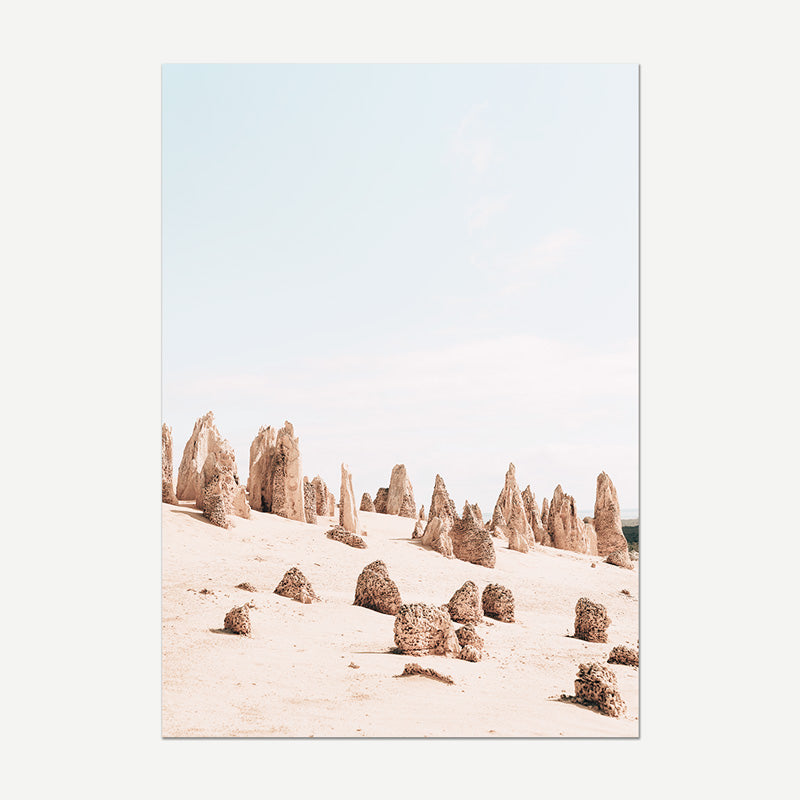 Desert landscape with sand dunes and rock formations under a clear sky