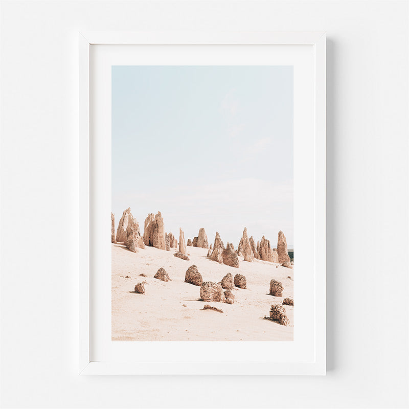 Framed artwork of a desert landscape with rock formations.